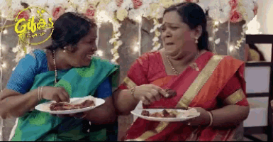 two women are sitting next to each other with plates of food in front of a sign that says ' gillias '