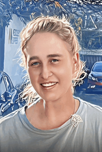 a woman wearing a blue shirt with a leaf necklace smiles for the camera