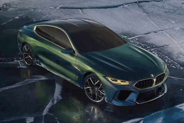 a green bmw is parked on a ice covered surface