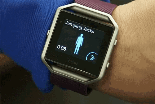 a fitbit watch on a person 's wrist shows jumping jacks