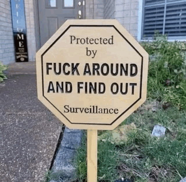 a wooden stop sign that says protected by fuck around and find out surveillance