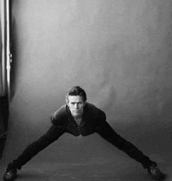 a black and white photo of a man doing a handstand