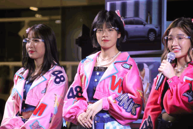 a woman wearing a pink jacket with the number 48 on the front