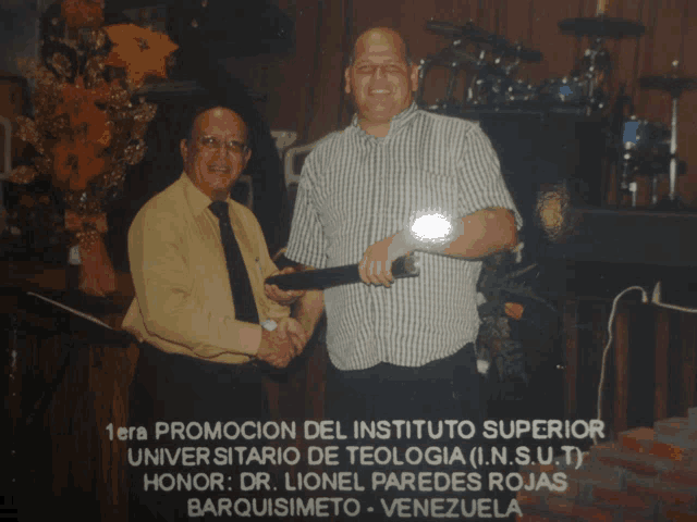 two men shaking hands in front of a sign that says " 1era promocion del instituto superior "