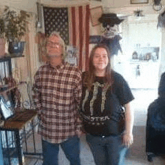 a man and a woman are standing next to each other in a living room holding hands .