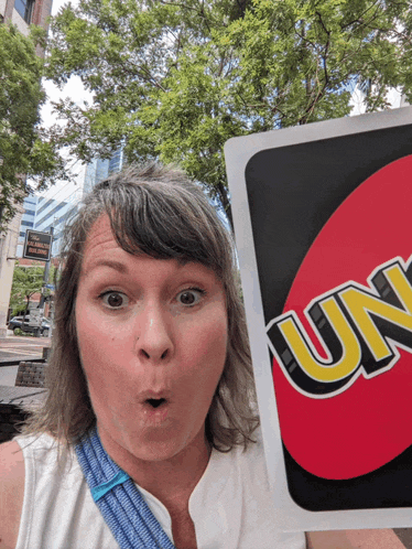 a woman holds up a card that says uno