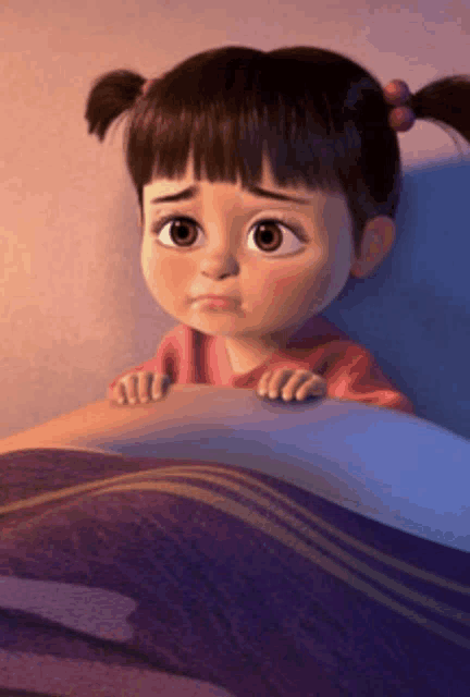 a little girl with pigtails is laying in bed with a purple blanket