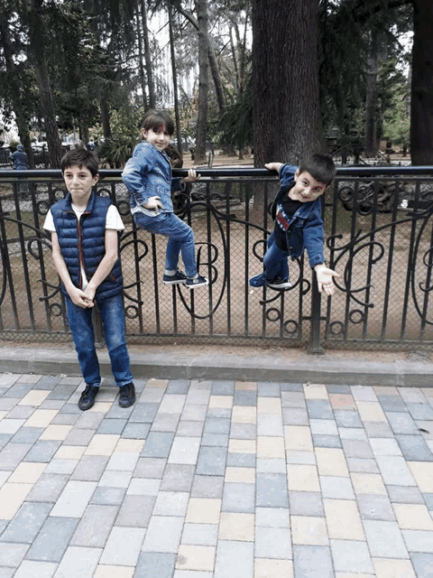 a boy wearing a black shirt that says ' freedom ' on it is standing next to two other boys