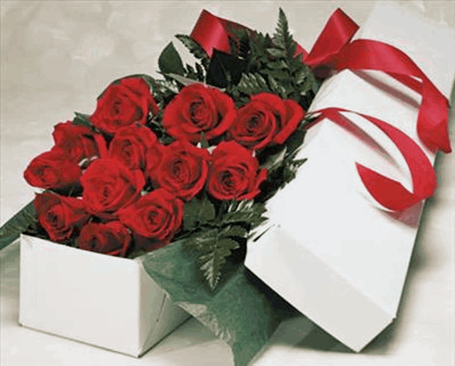 a box filled with red roses with a red ribbon