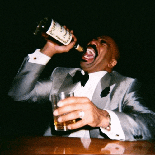 a man in a tuxedo drinking from a bottle of hennessy