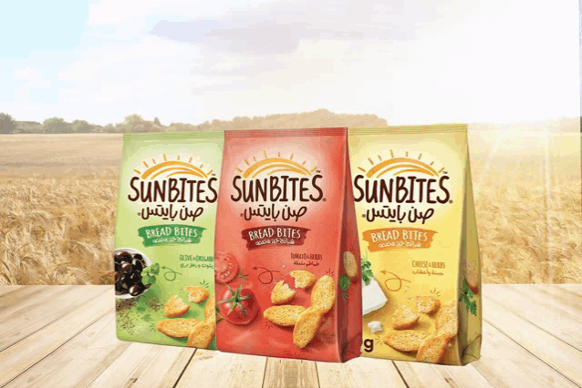 three bags of sunbites bread bites are lined up on a wooden table