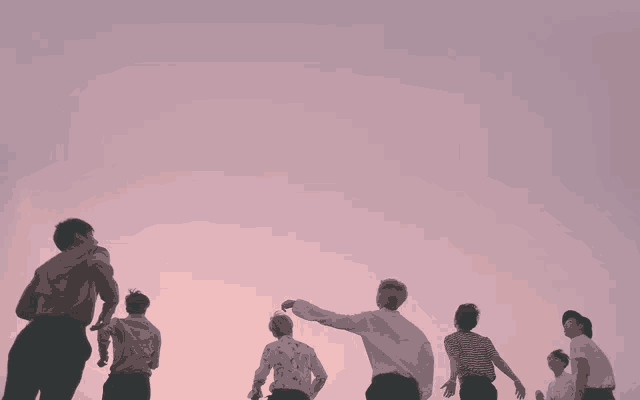 a group of men standing in front of a pink sky