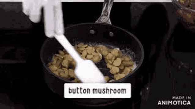 a person is stirring mushrooms in a pan on a stove .