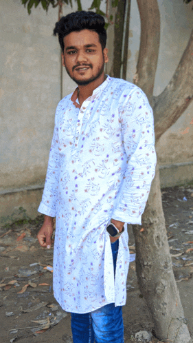 a young man wearing a white shirt with purple flowers on it