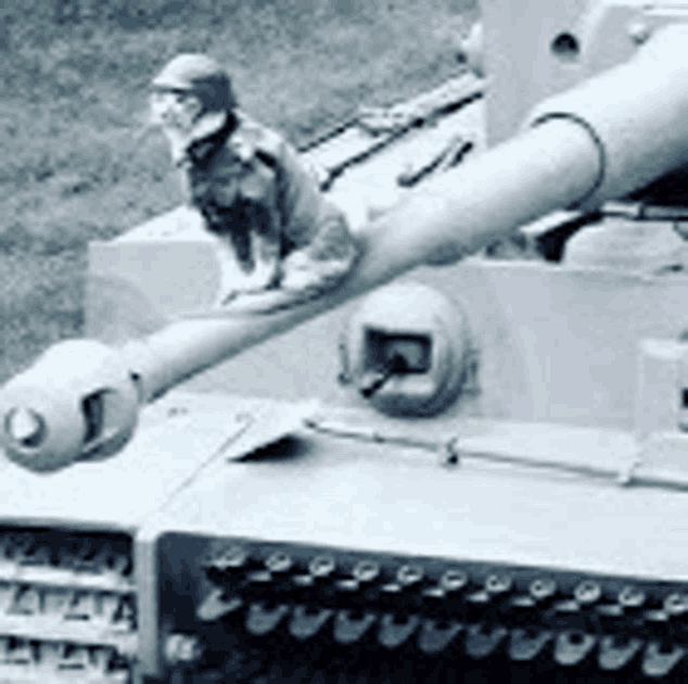 a black and white photo of a tank with a figurine of a soldier sitting on top of it .