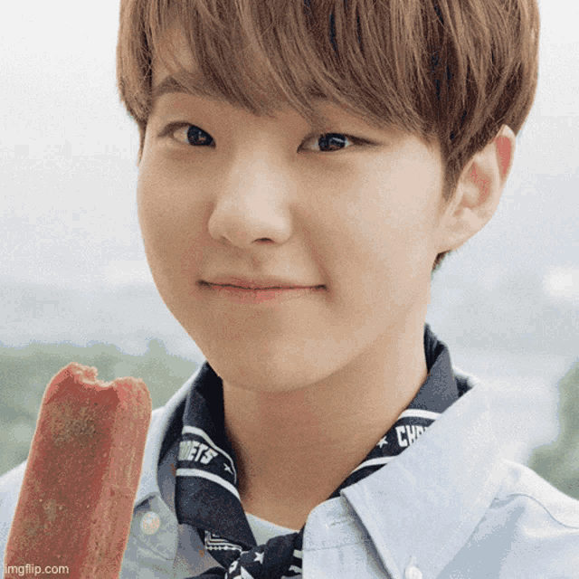 a close up of a young man holding a popsicle with a bandana that says ' rockets ' on it