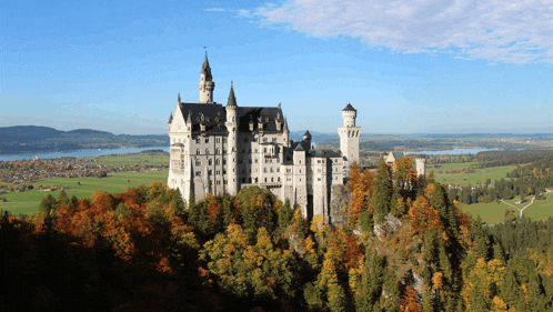 a castle sits on top of a hill with trees in front of it