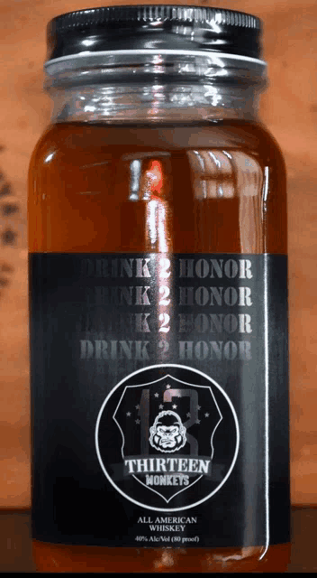 a bottle of thirteen monkeys all american whiskey sits on a wooden table