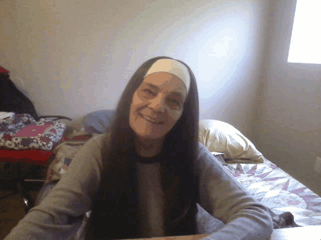 a woman with long hair wearing a headband is smiling