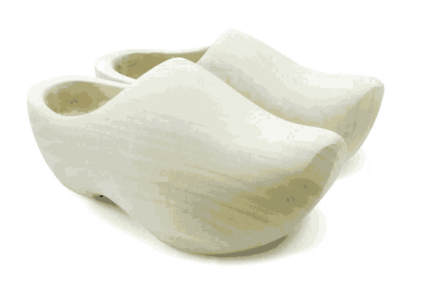 a pair of white wooden clogs on a white surface