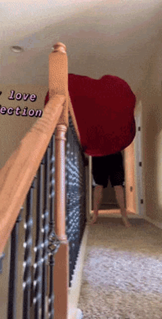 a person standing on a set of stairs holding a large red heart shaped blanket