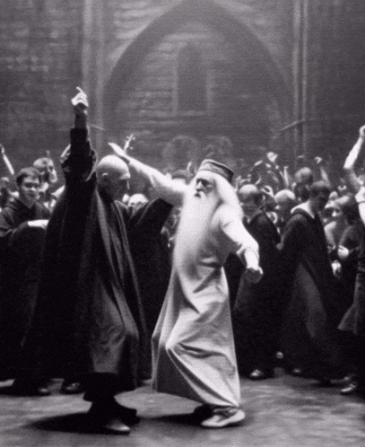 a man with a beard is dancing with another man in a crowd