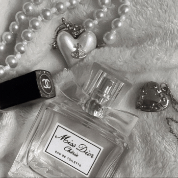 a bottle of miss dior perfume surrounded by pearls