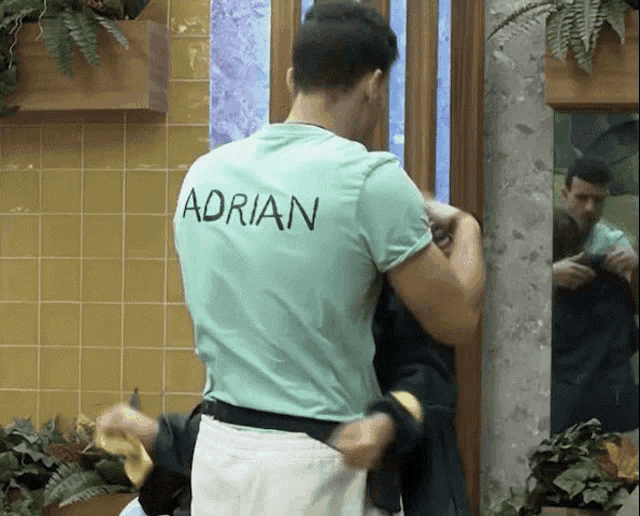 a man in a green shirt with the name adrian on the back