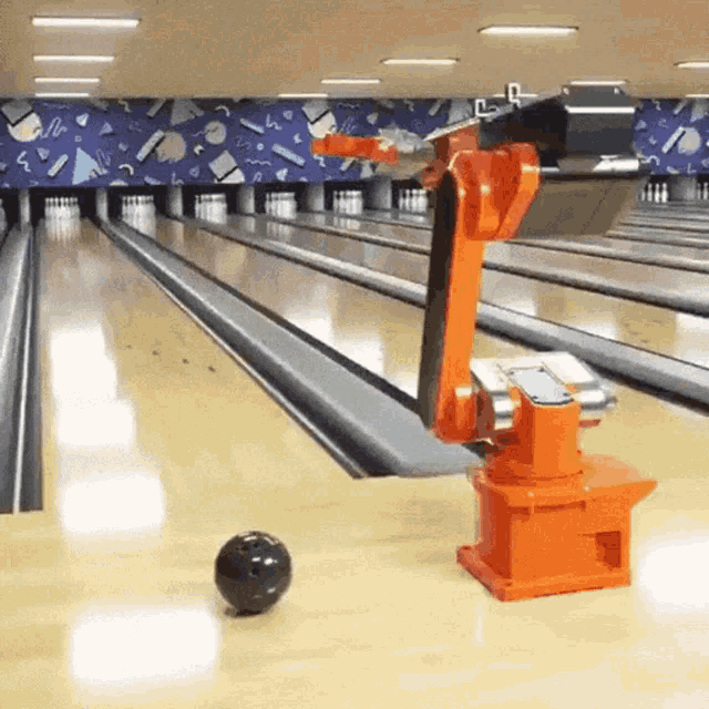 a bowling alley with a robotic arm playing bowling