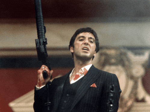 a man in a suit and vest is holding a gun