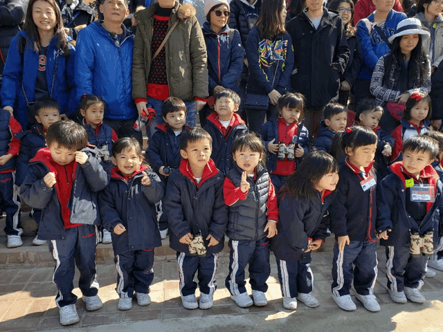 a group of children are posing for a picture and one of them is wearing a name tag that says ' a ' on it