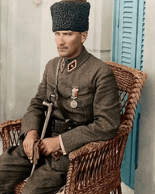 a man in military uniform is sitting in a wicker chair