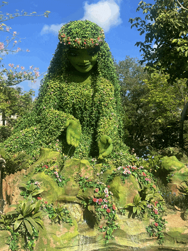 a statue of a woman made of green plants