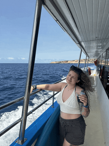 a woman stands on a boat holding a cup of coffee