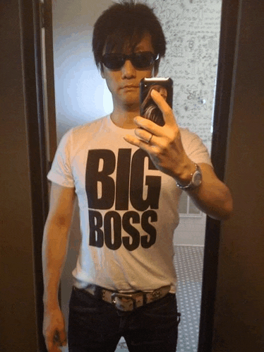 a man taking a picture of himself wearing a big boss t-shirt