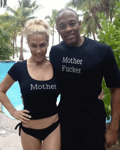 a man and a woman are posing for a picture and the woman is wearing a mother fucker shirt