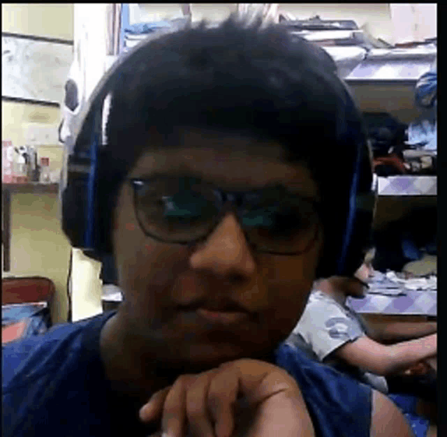 a young man wearing headphones and glasses is looking at the camera