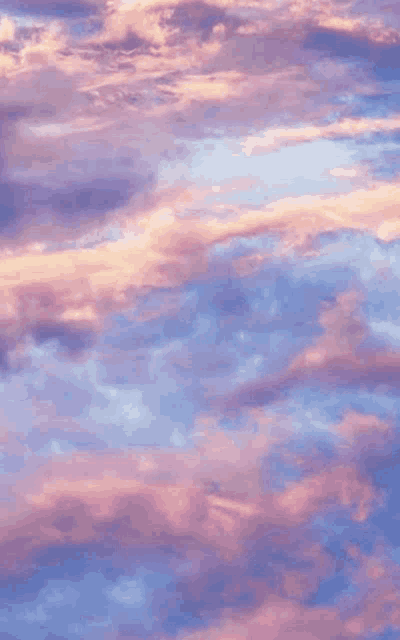 a purple and pink cloudy sky with a sunset in the background