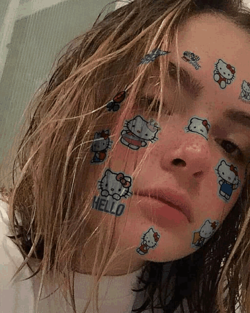 a girl with hello kitty face stickers on her face