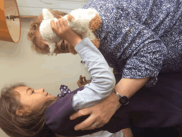 a woman wearing a watch holds a stuffed animal