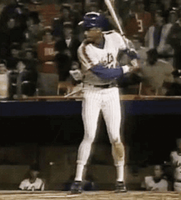 a baseball player wearing a jersey with the letter l on it is swinging a bat