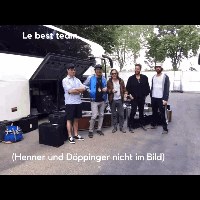 a group of men standing in front of a white bus with the words le best team written above them