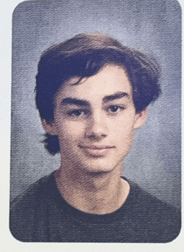 a close up of a young man 's face on a blue background