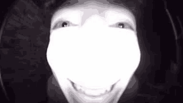 a close up of a person 's face in the dark with a white light coming out of it .