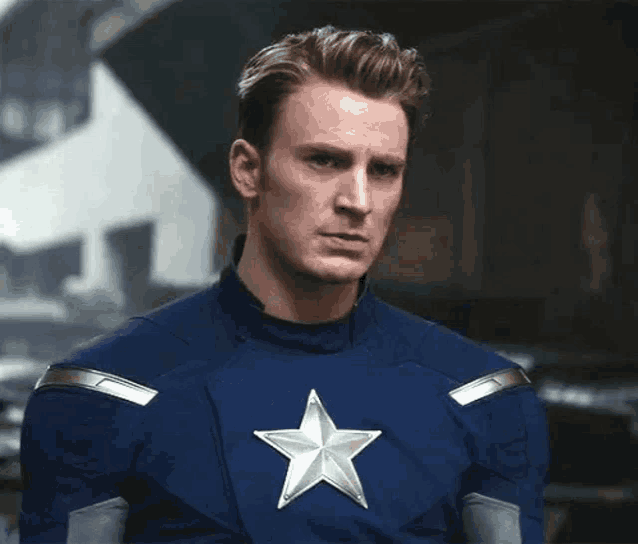 captain america is wearing a blue uniform with a silver star on the chest .