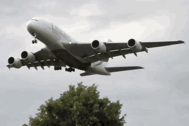 a large emirates airplane is flying through the air