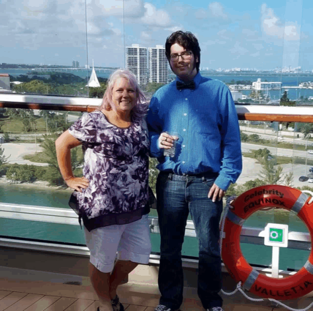 a man and a woman standing on a balcony with a life preserver that says celebrity equinox