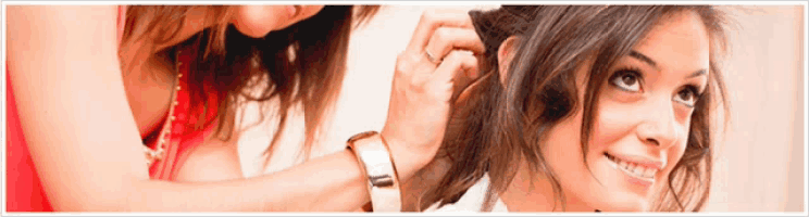 a woman is brushing another woman 's hair and the woman is smiling