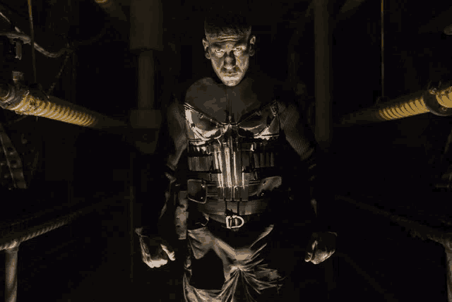 a man in a punisher costume stands in a dark hallway