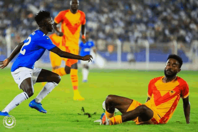 a soccer player with the number 2 on his jersey kicks the ball